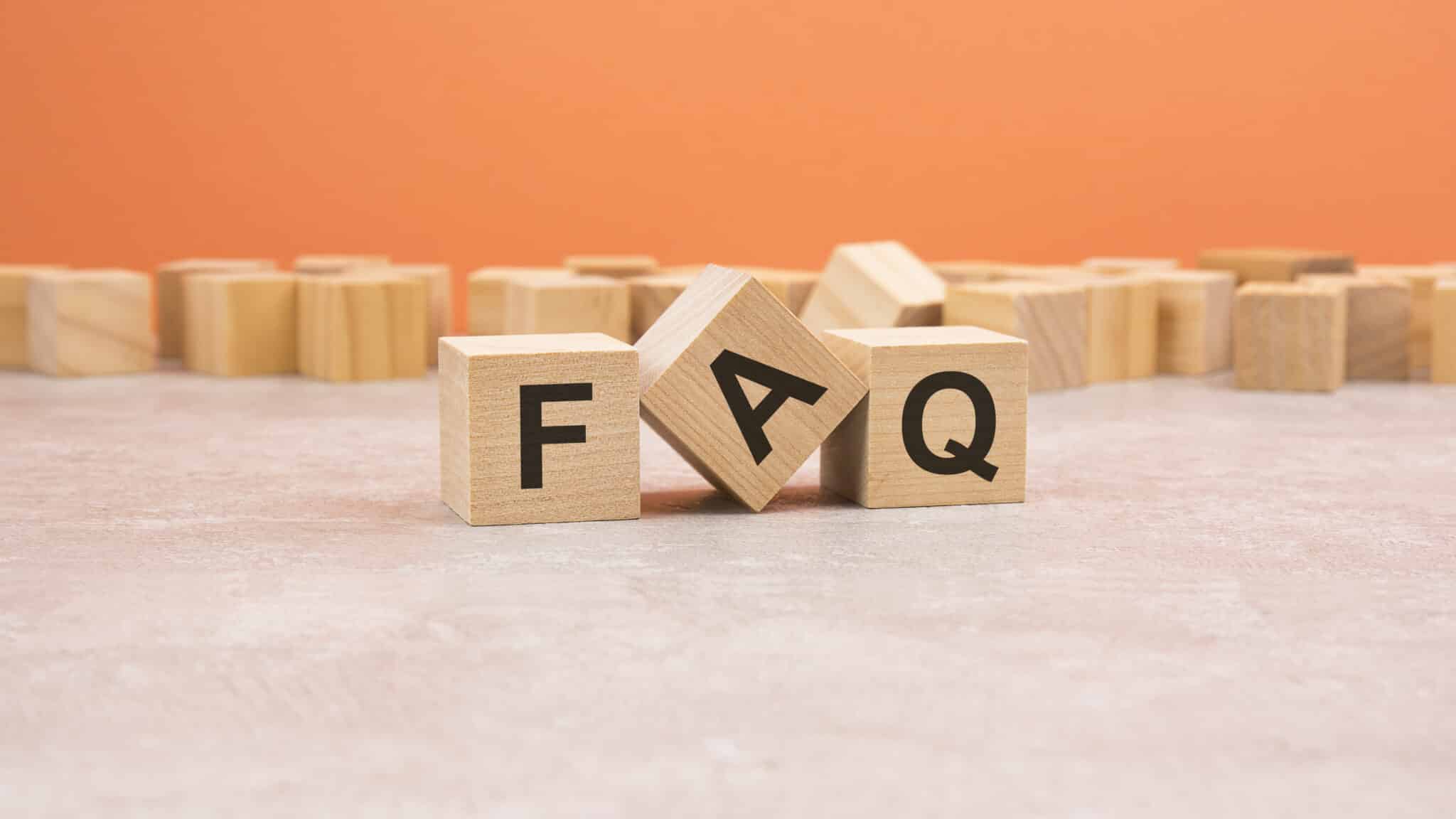 Heat Pump FAQ wooden blocks word on orange background.