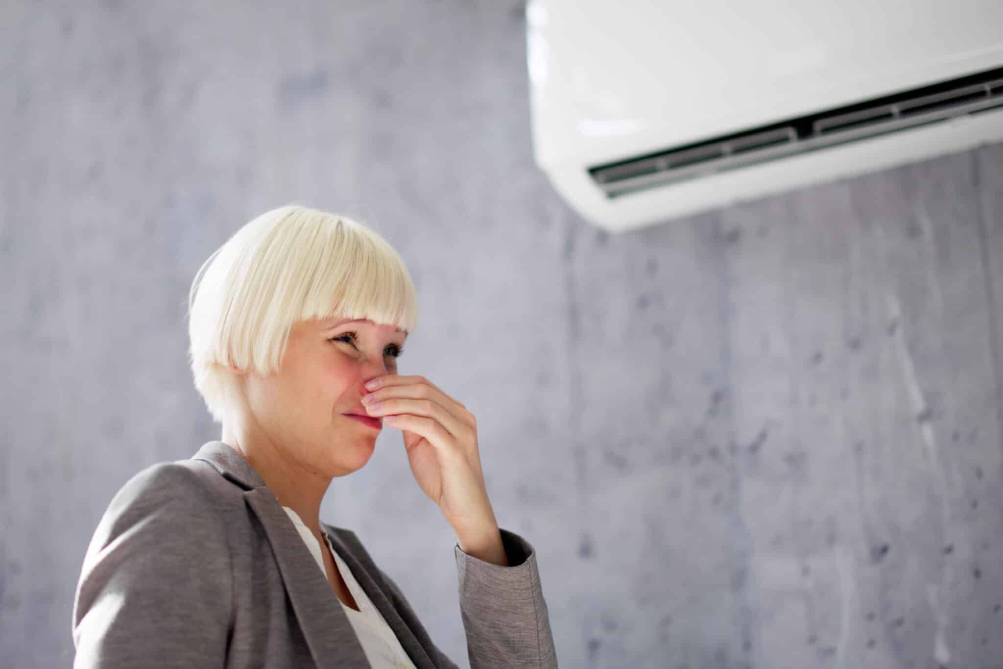 Woman covering her nose from bad smell, Duct Cleaners Near Me.